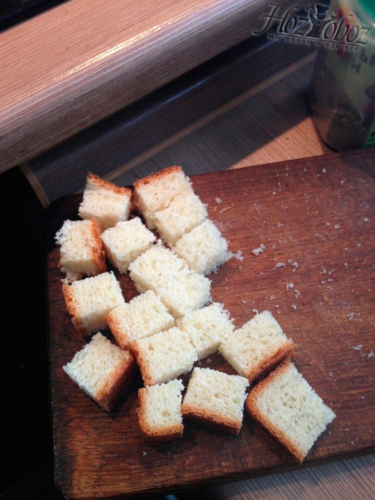 Порежте хлеб кубиками для приготовления сухариков для салата Цезарь