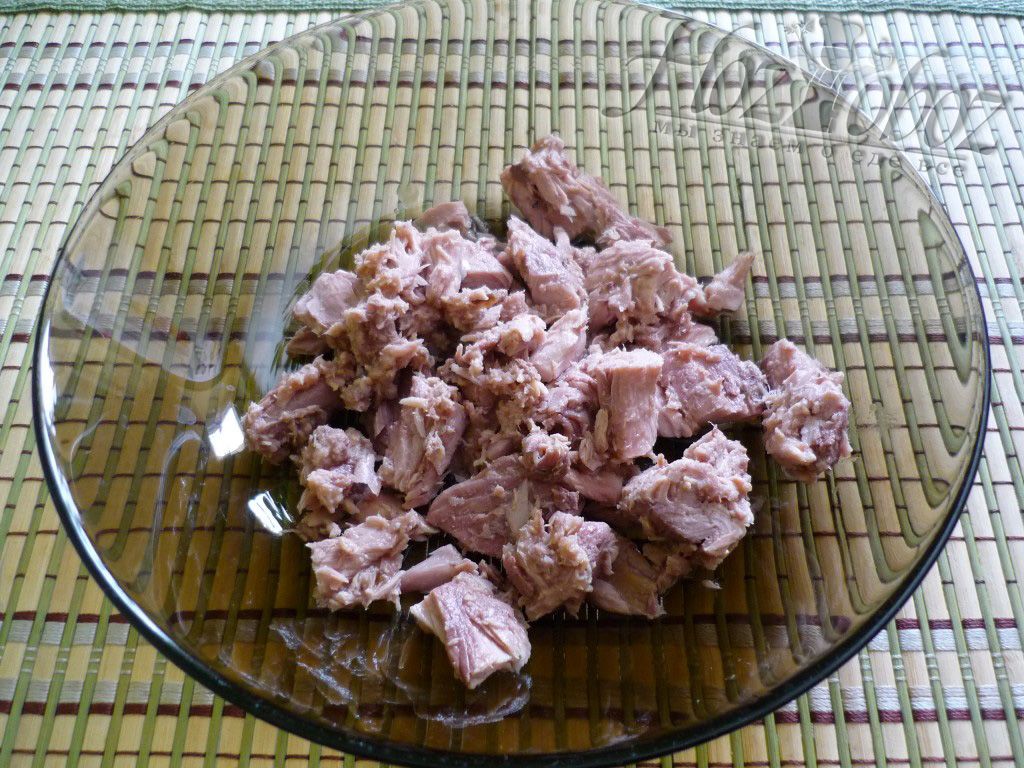 Переложите мясо тунца на тарелку и слегка измельчите