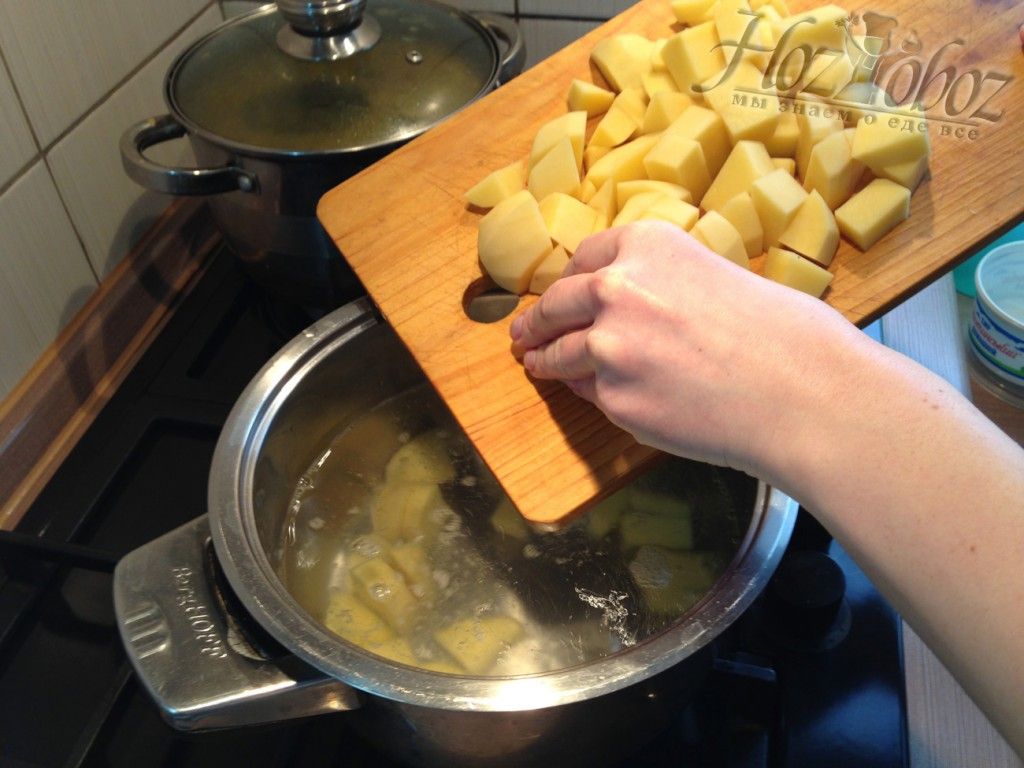 Высыпьте нарезанную кубиками картошку в кипящую воду