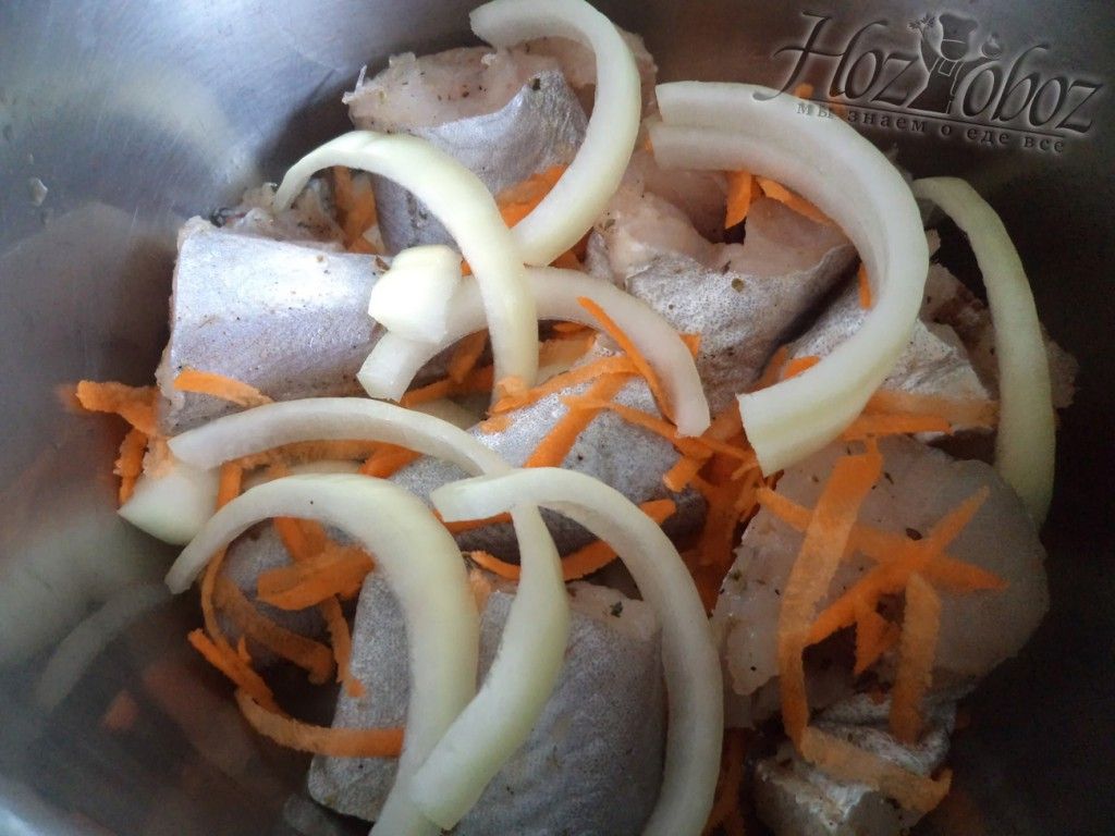 Покладите слой рыбы в кастрюлю, а так же лук и морковь