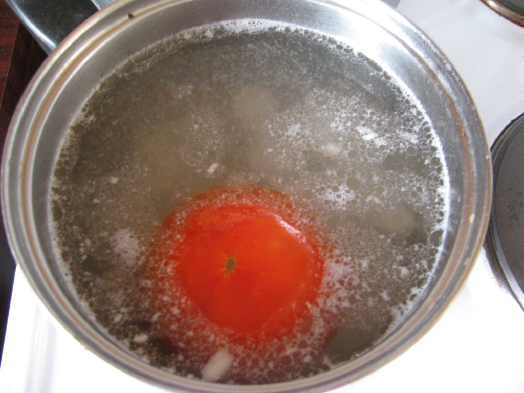 Кладем помидор в кипящую воду, предварительно обдав его кипятком