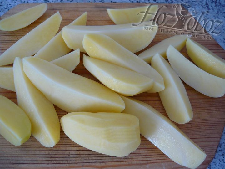 Нарежьте дольками очищенную картошку