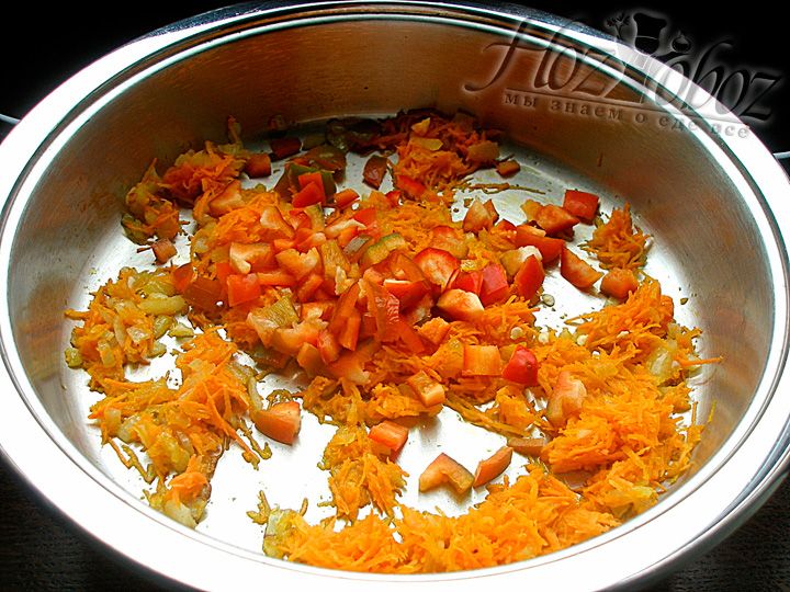 Добавляем тертую морковь и мелко нарезанный перец. Обжариваем еще несколько минут