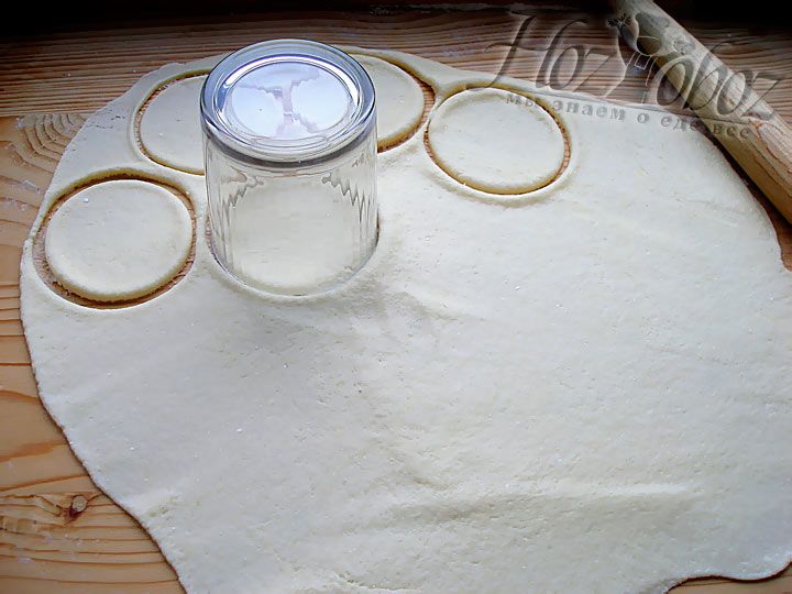 Раскатайте тесто и навырезайте кружочков из теста при помощи стакана