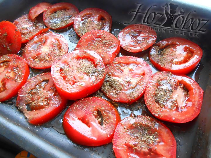 Рарложите помидоры по противню, полейте маслом и добавьте специи