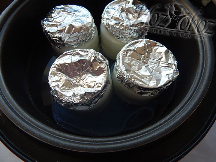 Баночки с будущим йогуртом помещаем в мультиварку, заливаем водой, доведенной до температуры 38 градусов, и готовим примерно 7 часов в режиме «Йогурт»