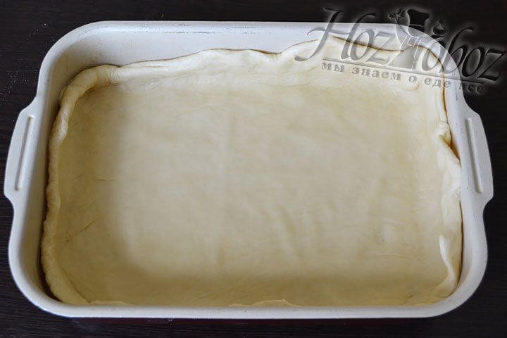 Смажьте противень подсолнечным маслом, застелите пергаментной бумагой и выкладывайте на него тесто распределяя по всей площади так чтобы края теста залазили на бортики формы
