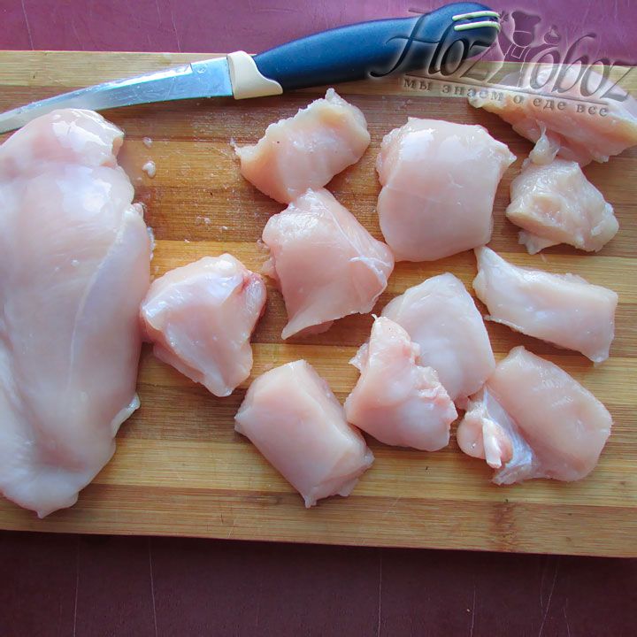 Нарежьте курицу на кусочки и выкладывайте в миску