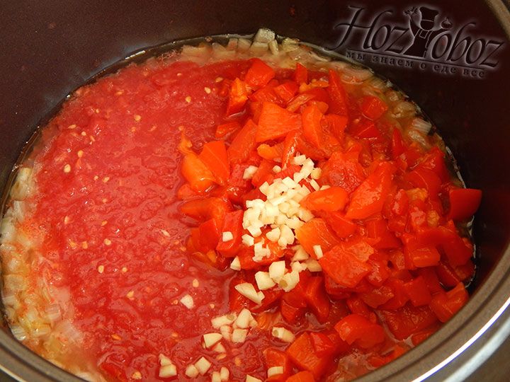 К обжаренному луку высыпаем томатное пюре, а также нарезанные перец и чеснок