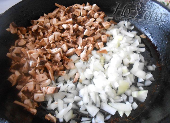 На разогретую сковороду с растительным маслом высыпаем грибы и лук. Слегка солим, обжариваем смесь до готовности