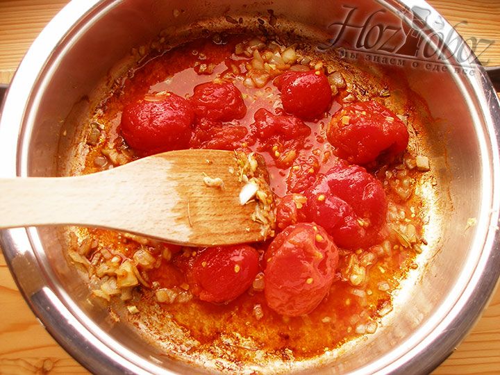 Добавляем в сковородку томаты в собственном соку, обжариваем их и размягчаем с помощью лопатки