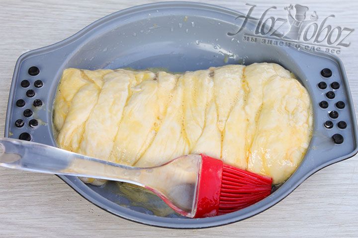 Противень смазываем растительным маслом и выкладываем на него кулебяку, которую смазываем взбитым яйцом