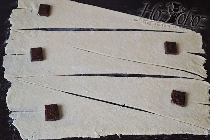 Из каждого пласта теста вырезаем определенное количество треугольников и на широкую часть каждого из них помещаем по кусочку шоколада