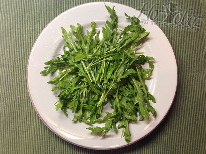 Начинаем составлять салат и в качестве первого слоя выкладываем на одну или несколько тарелок подушку из вымытого и высушенного зеленого салата «руккола»