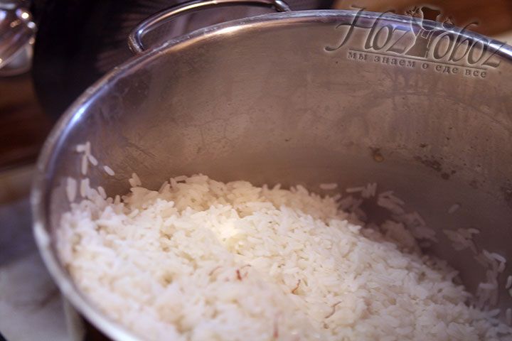 Рис, который варился 15 минут, уже готов так что пора слить с него воду и добавить немного масла