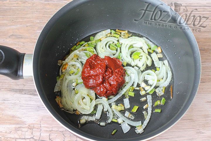 К обжаренному луку добавим томатную пасту и провариваем около минуты