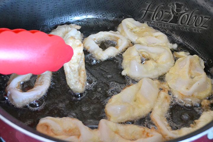 В сотейник с растительным маслом сухими руками выкладываем кальмаров, которые в процессе следует перевернуть щипцами