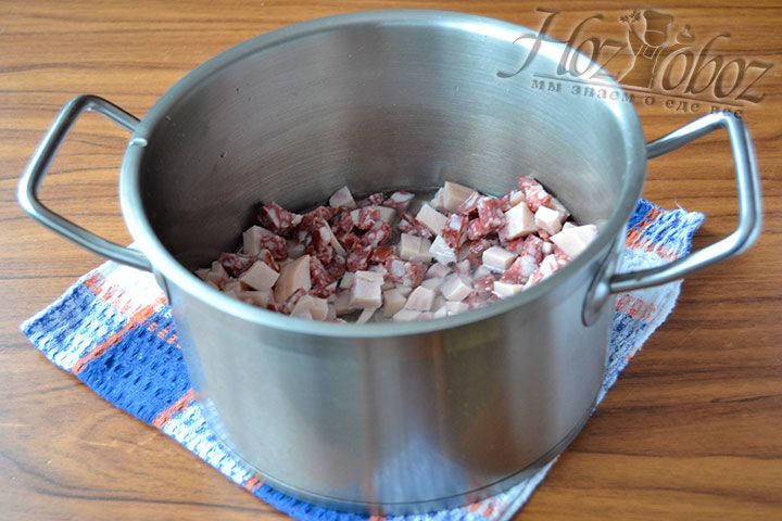 В кастрюлю кладем нарезанную кубиками колбасу и наполняем емкость 3 литрами чистой воды