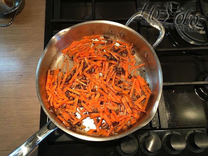 Морковку высыпаем к обжаренному луку и грибам и продолжаем пассировать