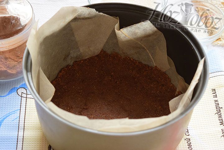 В чашу мультиварки застилаем пергамент и выкладываем основу для пирога приготовленную заранее из сладких крошек с какао маслом