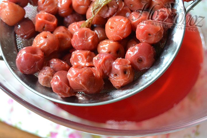 Когда компот настоится, отделите вареные ягоды с помощью сита