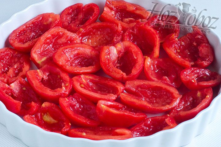 Очищенные томаты необходимо разрезать пополам и очистить от внутренних семян, а затем выложить все половинки в противень предварительно смазанный растительным маслом