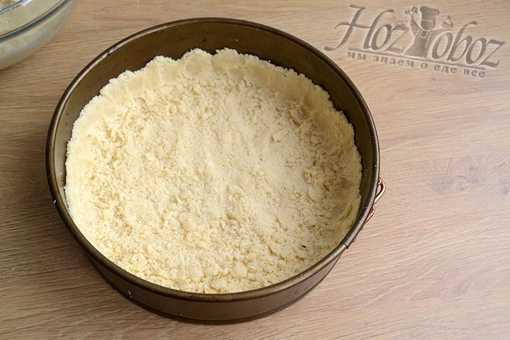 Форму для выпекания смажьте маслом, выложим 2/3 песочной крошки, разравниваем и формируем бортики