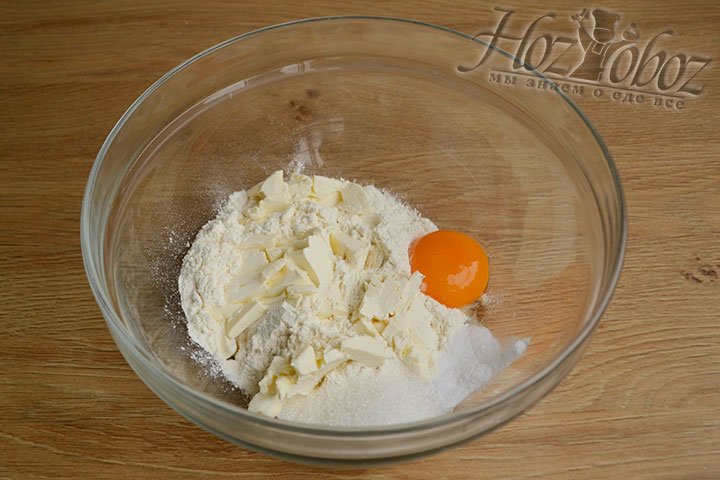 В глубокой миске соединяем муку, 1 желток, 1 ст. ложку сахара, пищевую соду и нарезанное кубиками масло.