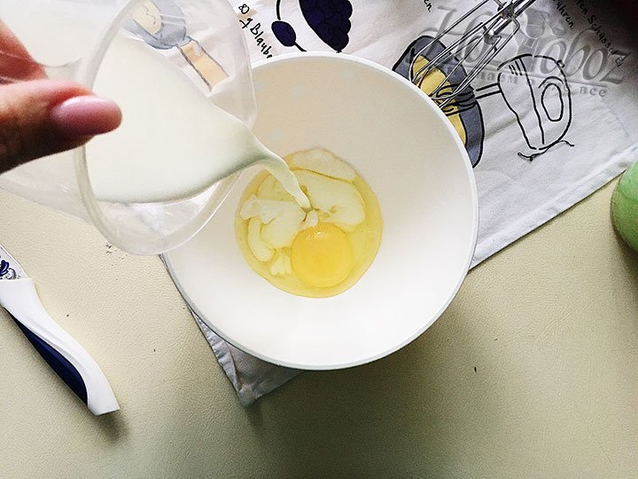 В миску разбиваем яйцо и вливаем молоко.